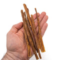 Größenvergleich: updog Welpen-Kausticks in einer Hand, ca. 15 cm lang und sehr schmal
